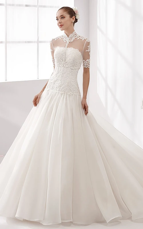 Vestido de novia de cuello alto y manga corta con falda abullonada y corpiño de encaje.
