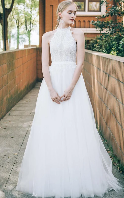 Robe de mariée élégante et vaporeuse, longue jusqu'au sol, en dentelle et tulle, coupe trapèze, sans manches.