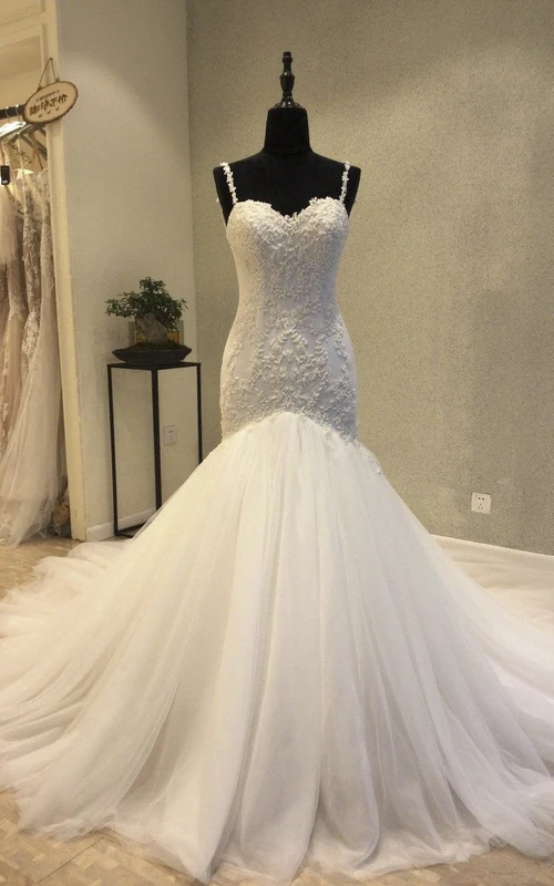Vestidos de novia estilo sirena con escote corazón, espalda descubierta, tirantes y apliques de encaje.