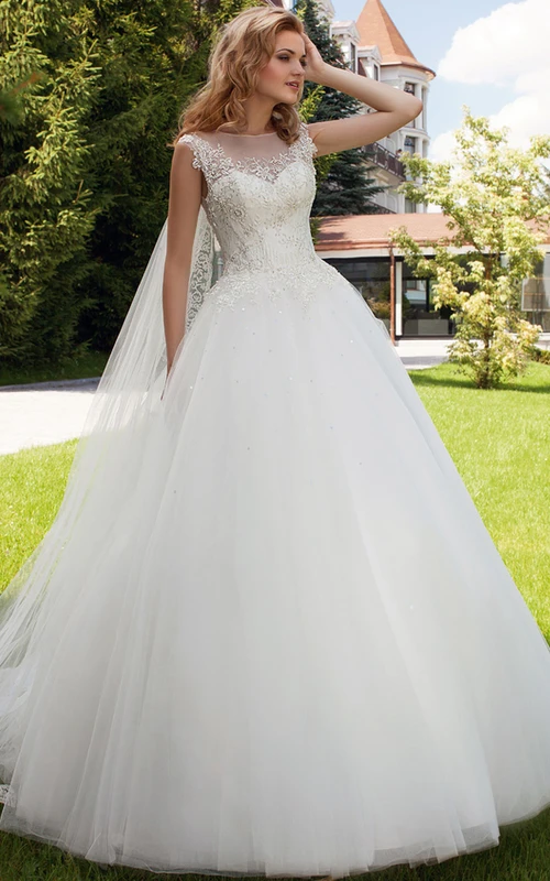 Vestido de novia largo de tul sin mangas con apliques, escote barco, espalda ilusión y cola de corte.