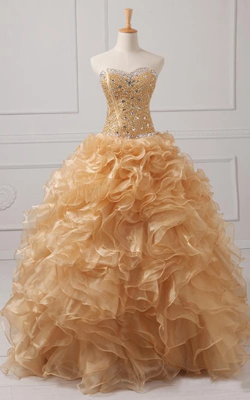 Vestido largo de organza con escote corazón, volantes, cremallera y corsé en la espalda.