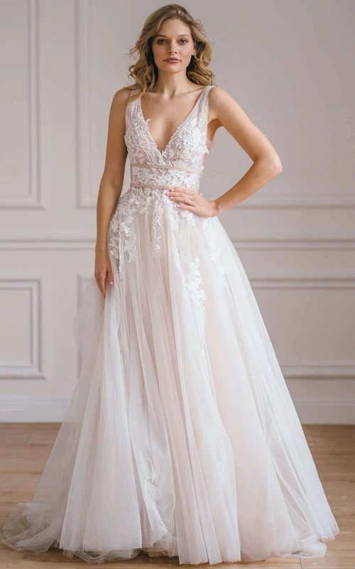Vestido de novia etéreo de corte A, largo hasta el suelo, sin mangas, con espalda descubierta y apliques.