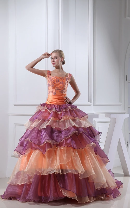Vestido de gala con volantes y escote cuadrado en tonos neutros y apliques.