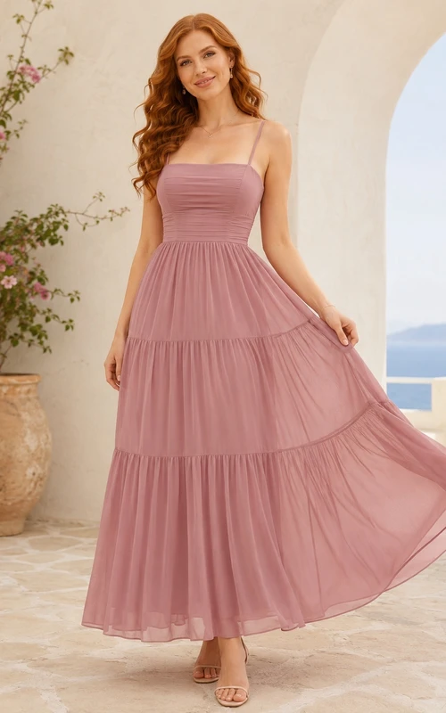 Robe fluide à bretelles spaghetti, sans manches, en mousseline rose poudré, longueur thé, à volants et coupe trapèze, sans manches.