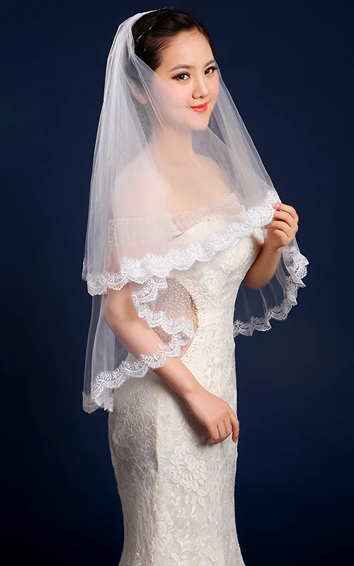 Voile de mariée simple en tulle à deux épaisseurs, arrivant aux coudes et bordé de dentelle.