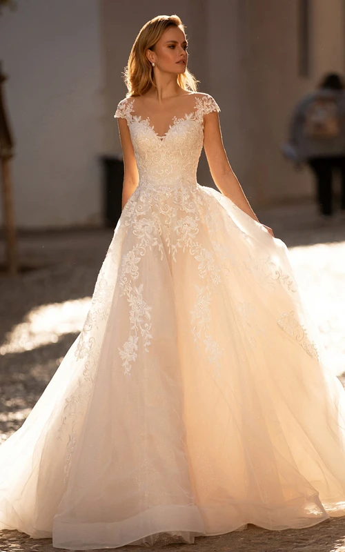 Vestido de novia romántico de encaje color champán con corte en A, mangas cortas y escote en V.