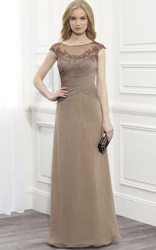 Robe de soirée longue trapèze en mousseline de soie à manches courtes et décolleté arrondi, ornée d'appliqués, avec dos illusion et fronces.