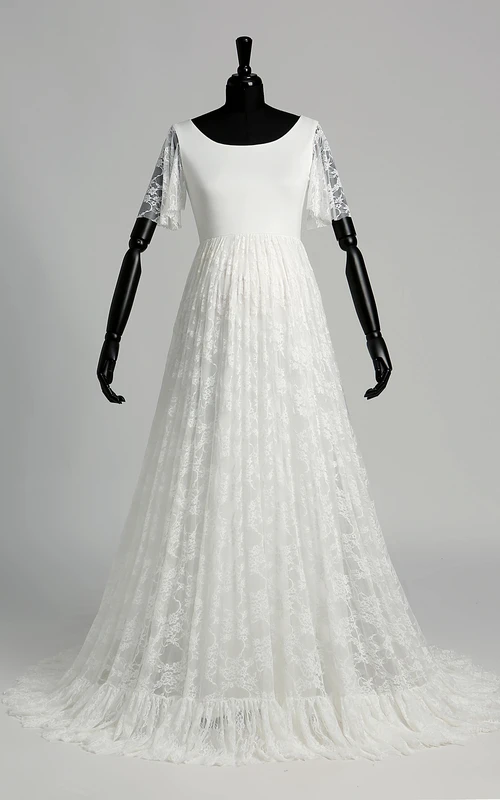 Robe de mariée en satin et dentelle, coupe trapèze, décolleté en V, manches courtes illusion, traîne courte.