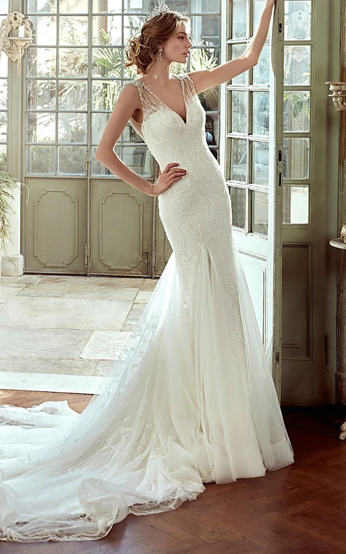 Vestido de novia de corte recto con escote en V, cola de corte sirena y espalda descubierta.
