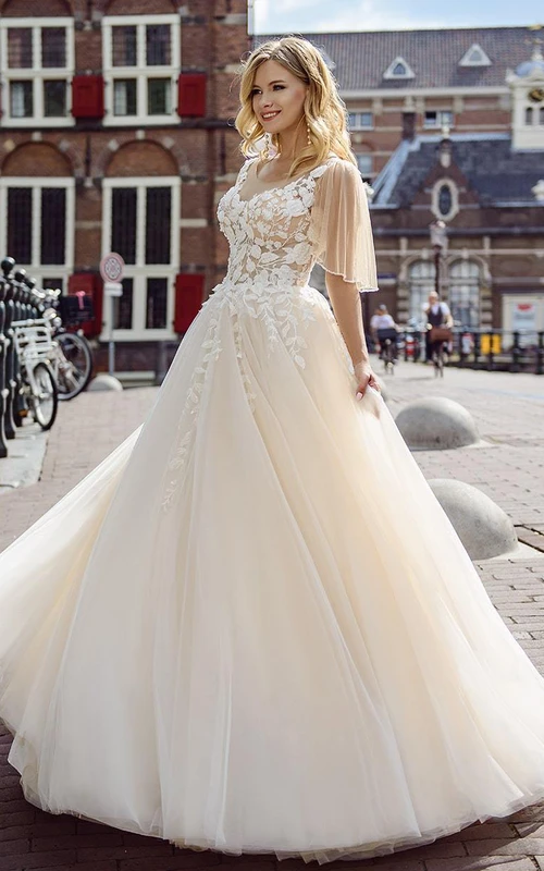 Vestido de novia romántico de corte princesa con escote en V, tul y encaje, cola de corte y fruncido.