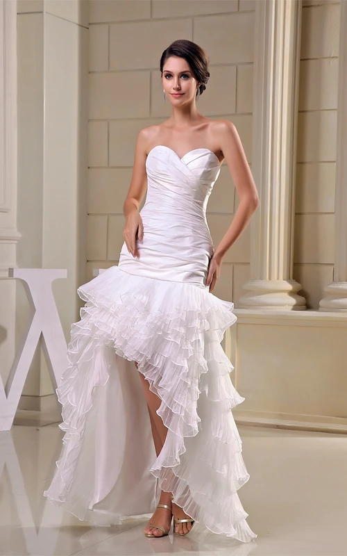 Vestido con escote corazón cruzado, capas asimétricas y fruncido.