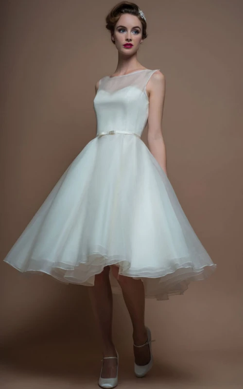 Vestido de novia corto de organza sin mangas, de corte A, largo hasta la rodilla, con escote barco y efecto ilusión.