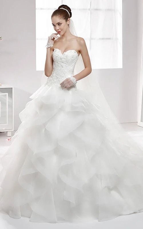 Vestido de novia de corte A con escote corazón, volantes en cascada y corsé con apliques de encaje.