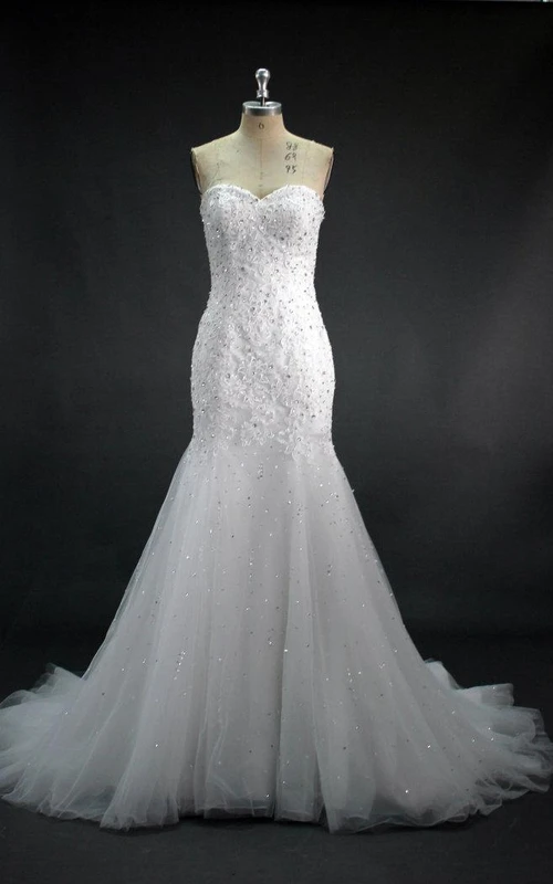 Vestido de novia de encaje y tul estilo sirena con escote corazón, adornado con cuentas y lentejuelas.