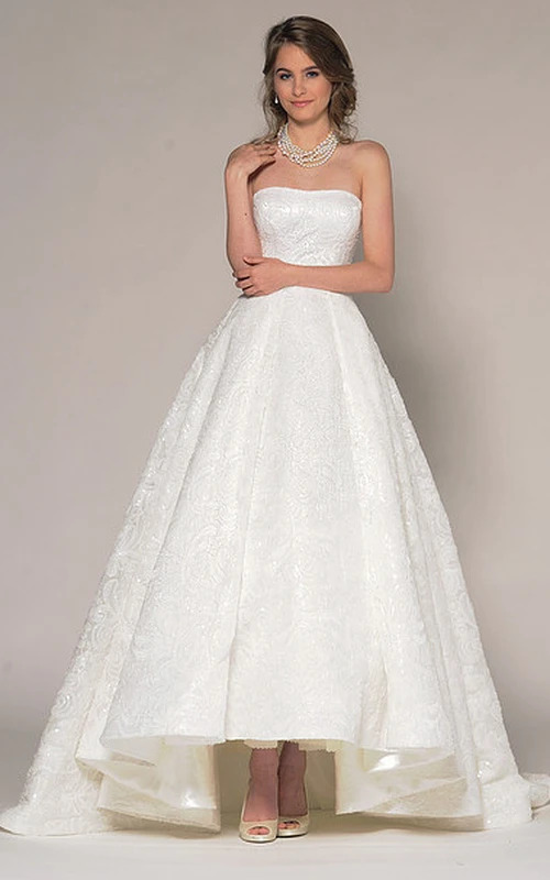 Vestido de novia asimétrico sin tirantes con encaje y pedrería en la espalda en V.