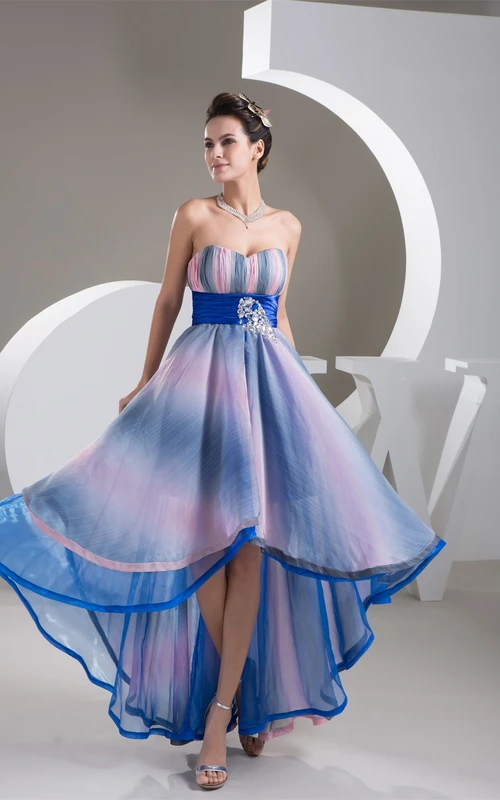 Kleid in gedeckten Farben mit Raffungen, asymmetrischem Saum, Strasssteinen und Falten