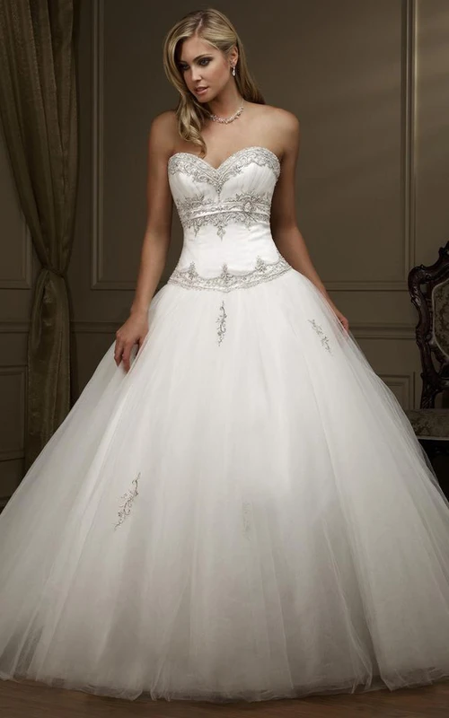 Vestido de novia de gala con escote corazón, tul, pedrería y cordones.