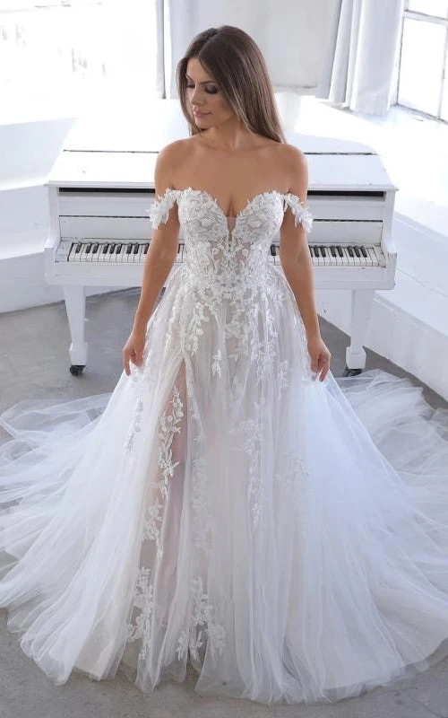 Robe de mariée empire vaporeuse en tulle à épaules dénudées, coupe trapèze, ornée d'appliqués de dentelle et de dentelle.