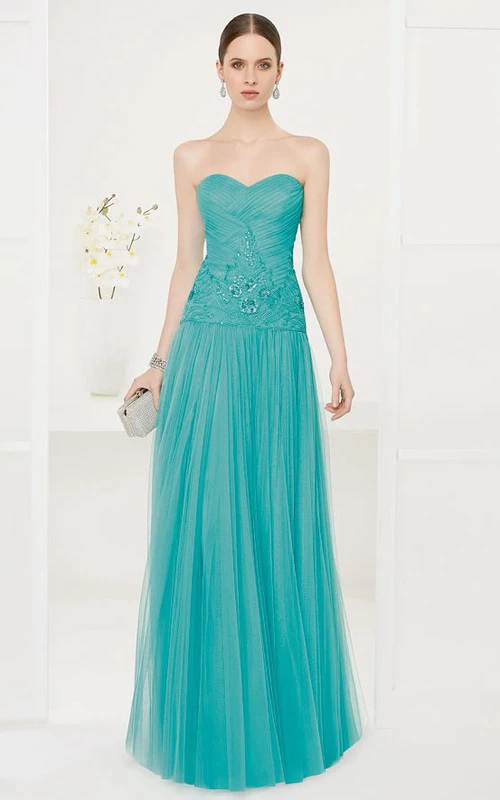 Robe de bal longue en tulle, coupe trapèze, décolleté en cœur et broderie de sequins