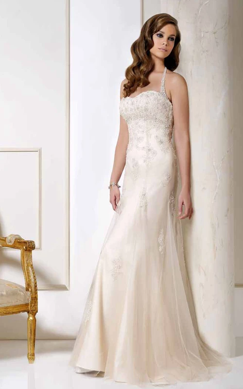 Robe de mariée longue en tulle ornée d'appliqués, dos nu, avec traîne courte et décolleté en V.