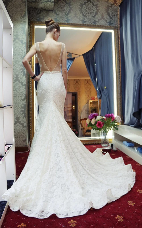 Vestido de encaje sin mangas estilo sirena con escote joya, espalda en V profunda y fajín con cuentas.