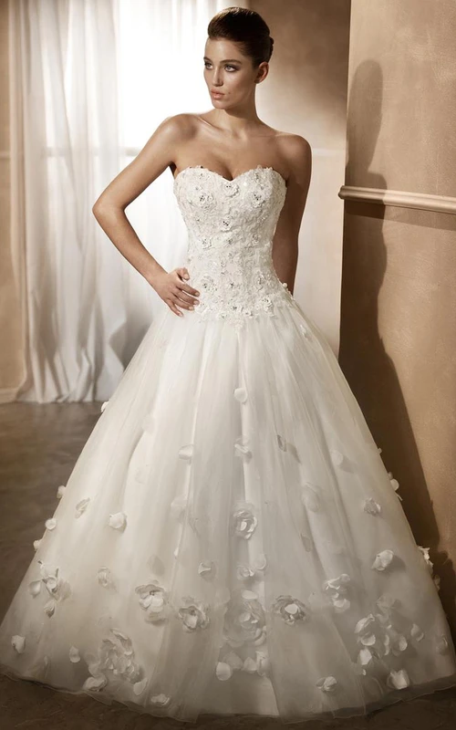 Vestido de novia de tul con apliques y escote corazón, estilo princesa, adornado con flores.