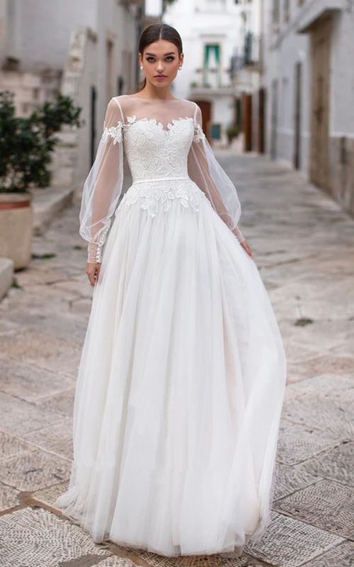 Robe de mariée élégante à manches longues et coupe trapèze, ornée d'appliqués et de plis, longueur au sol.