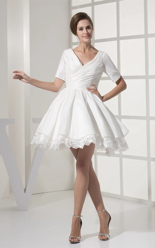 Vestido corto de manga corta con escote en V cruzado y apliques.