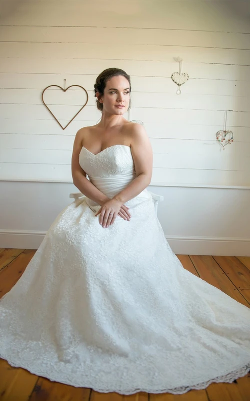 Vestido largo de corte A con escote corazón, sin mangas y cola de encaje.