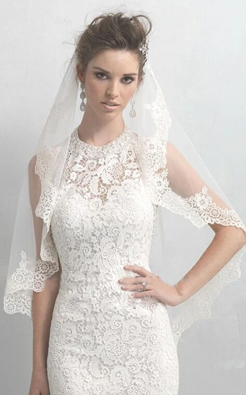 Voile en tulle souple arrivant aux coudes, bordé d'appliqués de dentelle.
