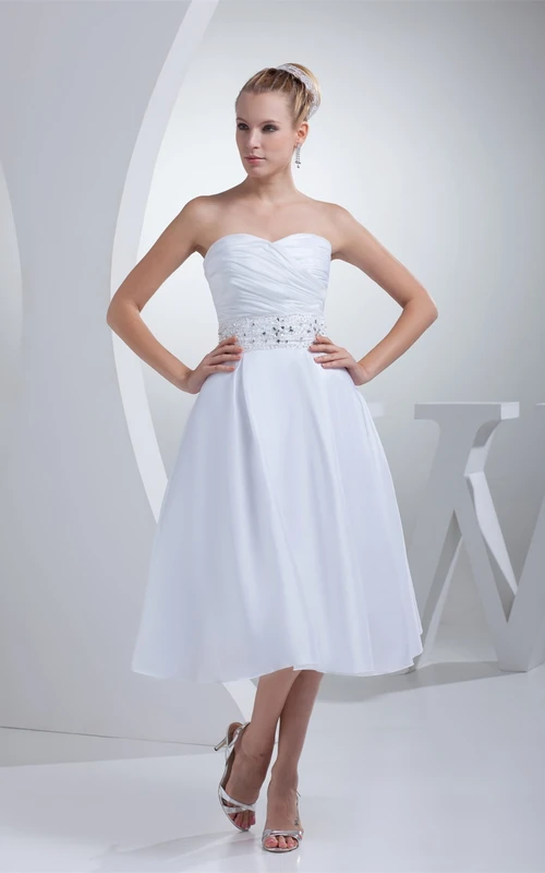 Vestido de corte A hasta la rodilla con escote corazón, cintura adornada con joyas y fruncido.