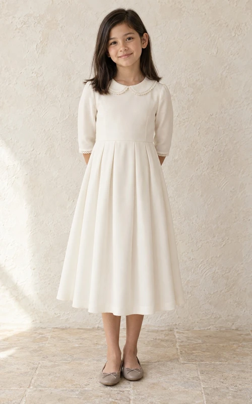 Robe de demoiselle d'honneur ivoire simple et modeste, longueur thé, col rond, poignets en dentelle à petits lacets, manches trois-quarts cintrées, plis groupés, finition mate, fermeture éclair au dos.