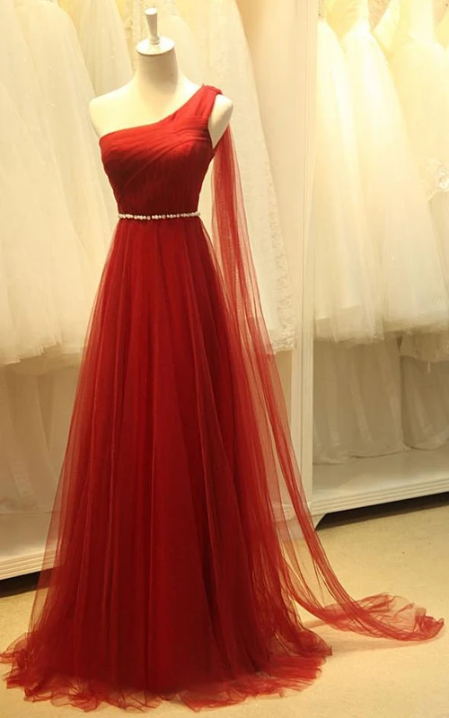 Vestido largo de tul asimétrico con escote en A y detalles de pedrería.