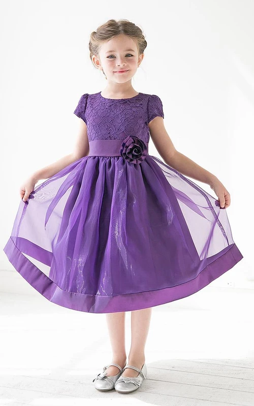 Robe de demoiselle d'honneur mi-longue à volants en dentelle et organza fleurie avec ceinture.