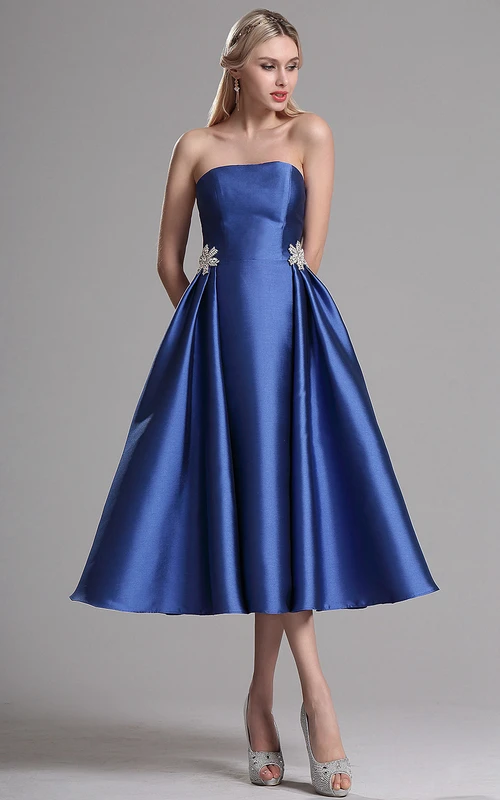 Vestido de satén sin tirantes, largo hasta la rodilla, con estampado floral y cremallera.