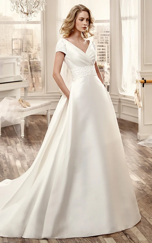 Vestido de novia largo de satén con escote en V, cola de corte clásico, espalda baja en V y cinturilla floral.