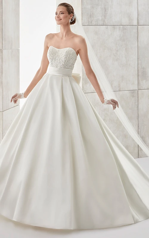 Vestido de novia palabra de honor de corte A con cintura ajustada y lazo en la espalda.