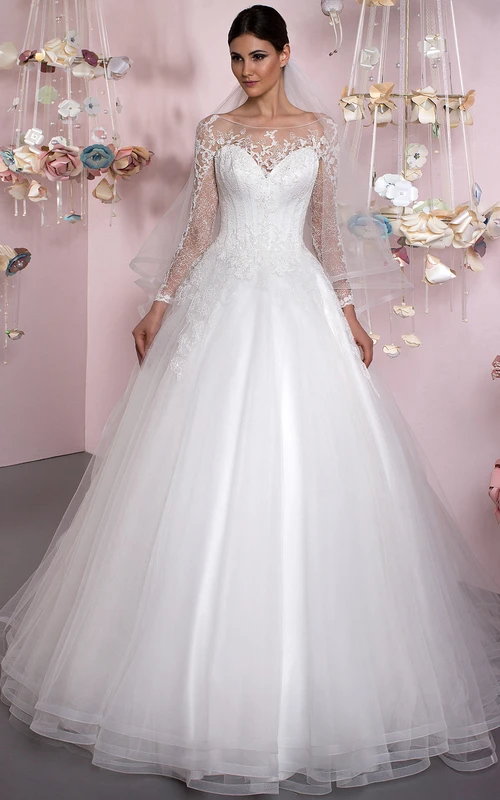 Vestido de novia de princesa con escote barco, apliques y mangas largas de tul.