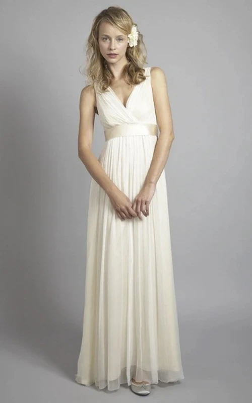 Vestido de novia de gasa sin mangas con escote cruzado y espalda en V baja.