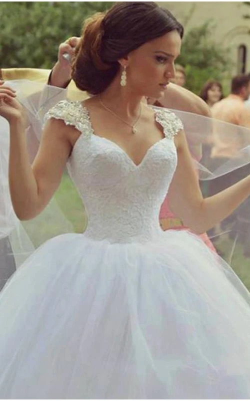Delicado vestido de novia de tul sin mangas con escote corazón y falda de gala.