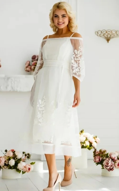 Vestido de novia etéreo de corte A, largo hasta la rodilla, de tul, con mangas tres cuartos y botones, con apliques.