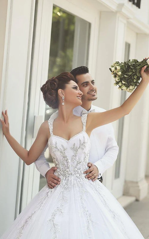 Vestido de novia de tul con tirantes delicados, bordados y apliques, estilo princesa.