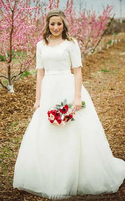 Robe de mariée princesse modeste, col rond, manches courtes, haut en dentelle, longueur thé, avec ceinture.