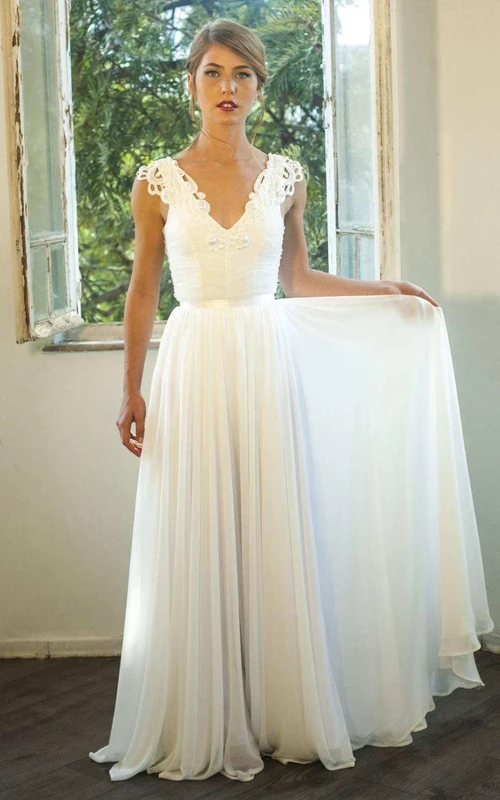 Robe de mariée dos nu en mousseline froncée à manches courtes et décolleté plongeant ornée d'appliqués