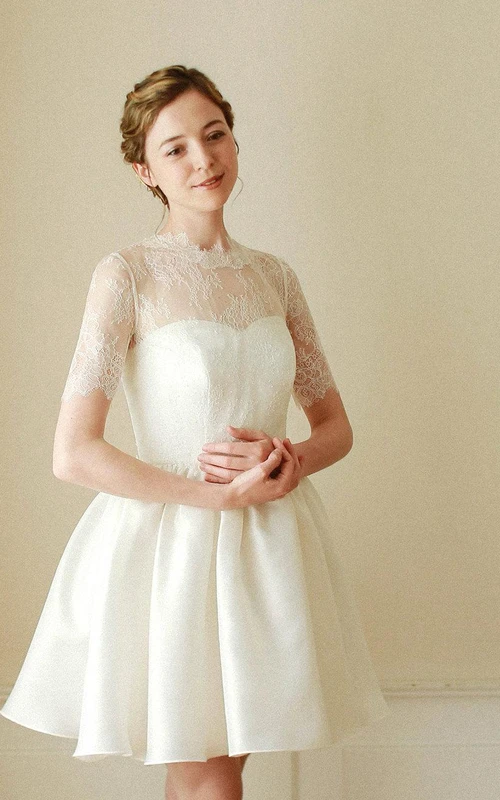 Vestido corto de satén con corpiño de encaje, corte en A, mangas cortas y cuello alto.