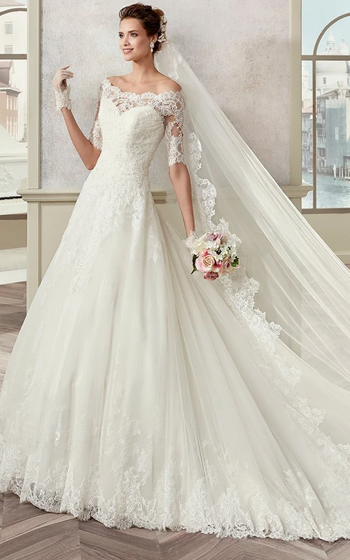 Vestido de novia de corte A con hombros descubiertos, mangas cortas y escote festoneado.
