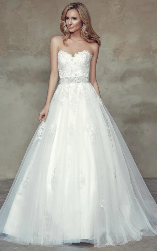 Vestido de novia de tul con escote corazón, adornado con joyas y lazo.