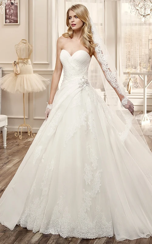 Vestido de novia de corte A con escote corazón, cintura floral lateral y bordados.