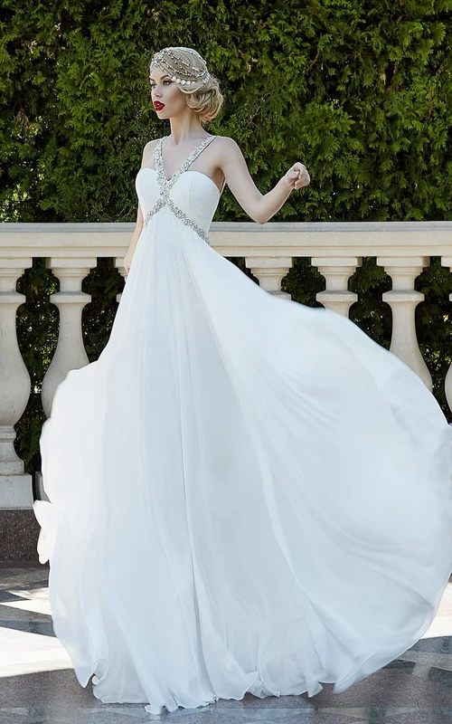 Vestido largo de gasa con escote halter, sin mangas, corte imperio, con cordones y abalorios.