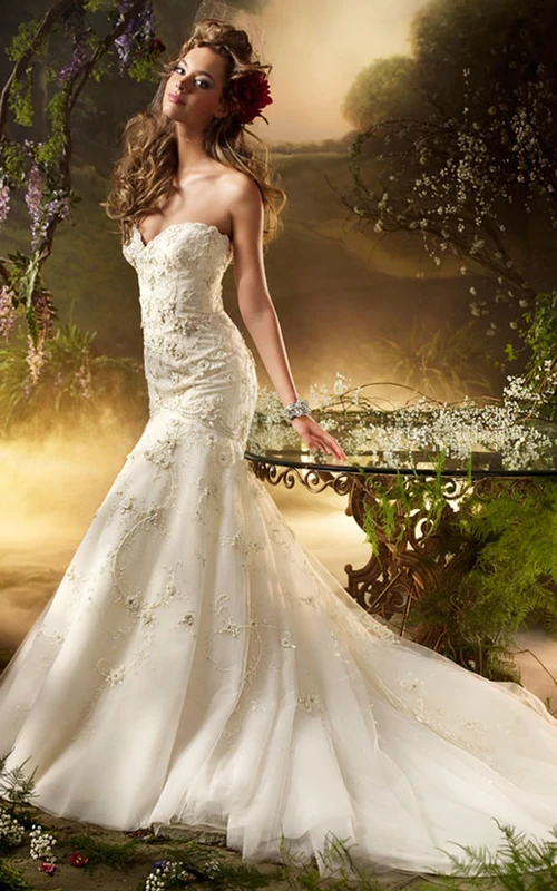 Exquisito vestido de tul bordado con cuentas y adornos florales.